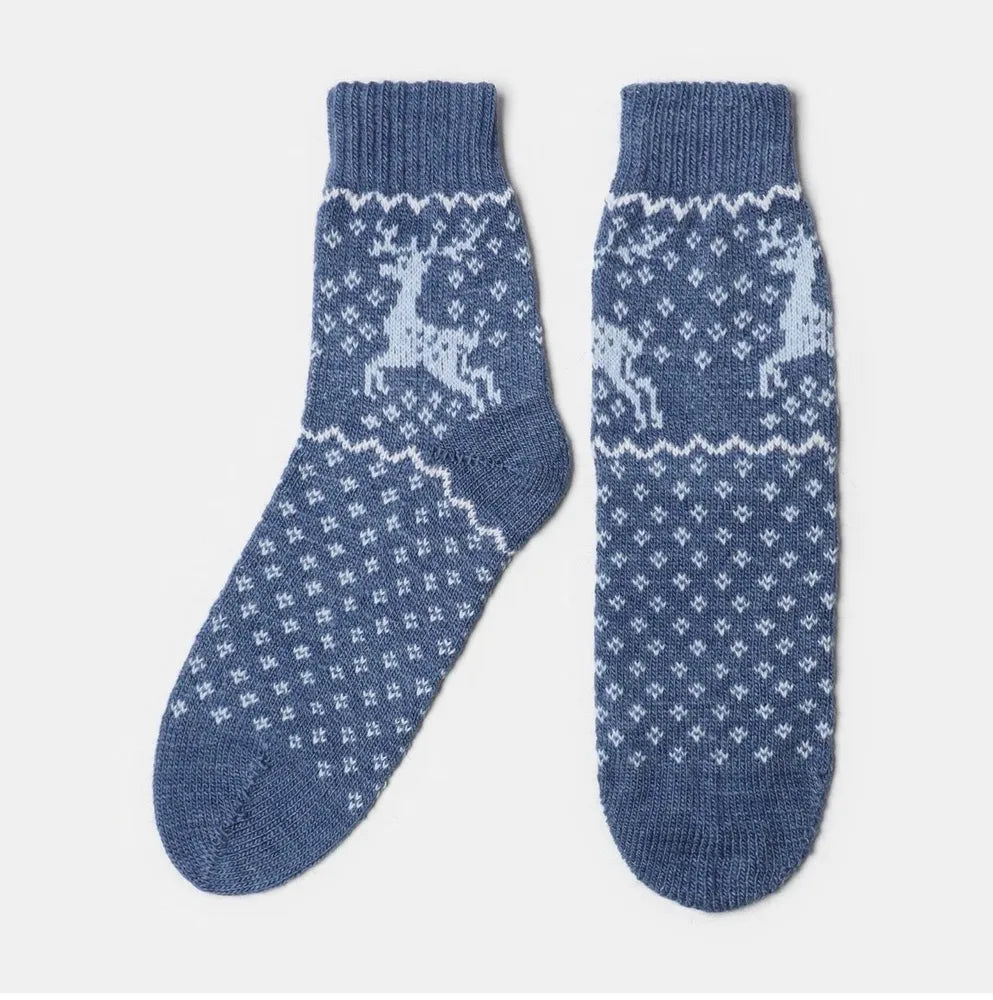 Подарочный набор к Новому году, включающий плед, чай и шерстяные носки.